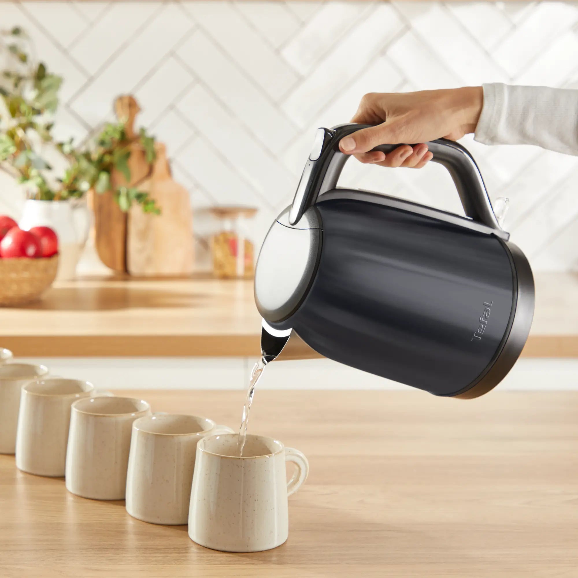 Tefal Subito Black Stainless Steel Toaster & Kettle Breakfast Set with toast in toaster in use pouring boiling water